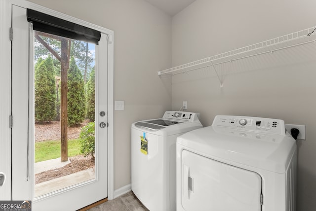 laundry area featuring washing machine and dryer, a wealth of natural light, and light wood-type flooring