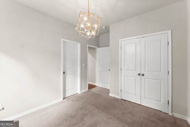 unfurnished bedroom featuring a closet, carpet, and a chandelier