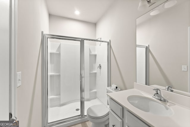 bathroom featuring vanity, toilet, and an enclosed shower