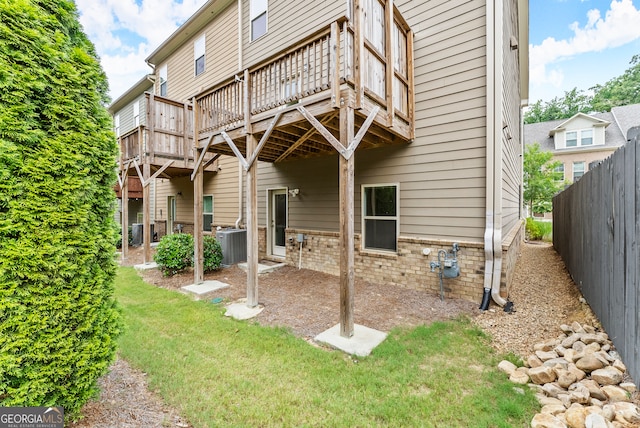 back of house with a yard, central AC unit, and a deck