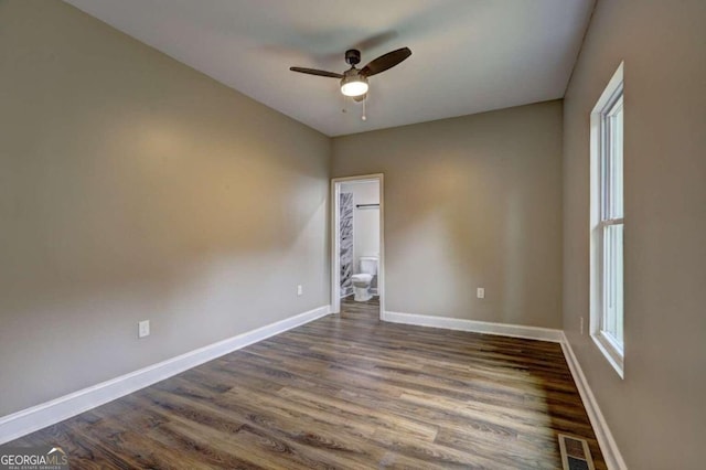 empty room featuring dark wood-type flooring and ceiling fan