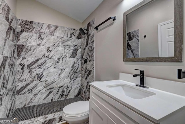 bathroom featuring a tile shower, vanity, toilet, and lofted ceiling