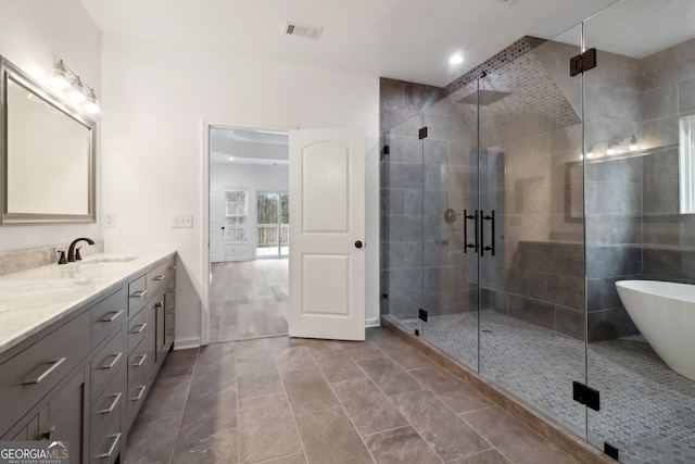 bathroom featuring tile patterned flooring, vanity, and shower with separate bathtub