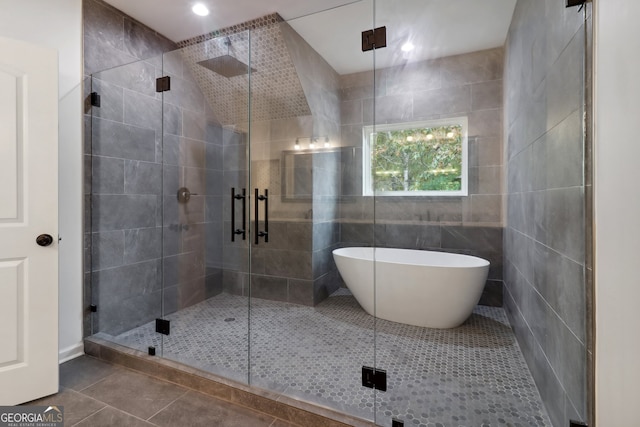 bathroom with independent shower and bath, tile walls, and tile patterned floors