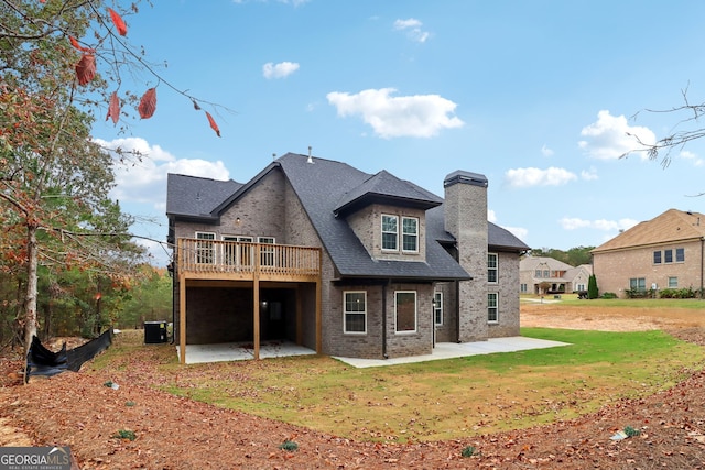 rear view of property featuring a patio area, central AC, and a lawn