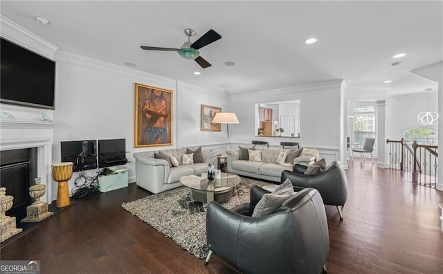 living room with dark wood-type flooring, ceiling fan, and ornamental molding