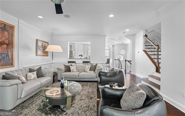 living room with dark wood-type flooring, ceiling fan, and ornamental molding