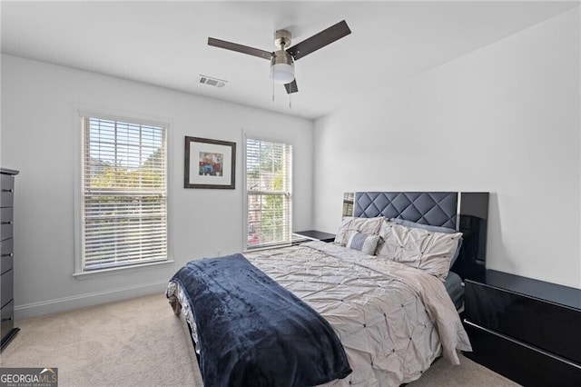 carpeted bedroom with multiple windows and ceiling fan