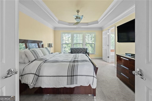 carpeted bedroom with ornamental molding, ceiling fan, and a raised ceiling