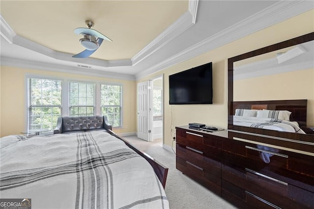 bedroom featuring ensuite bath, crown molding, a raised ceiling, light colored carpet, and ceiling fan