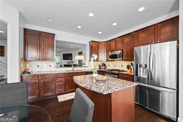 kitchen with stainless steel appliances, dark wood-type flooring, decorative backsplash, and a center island