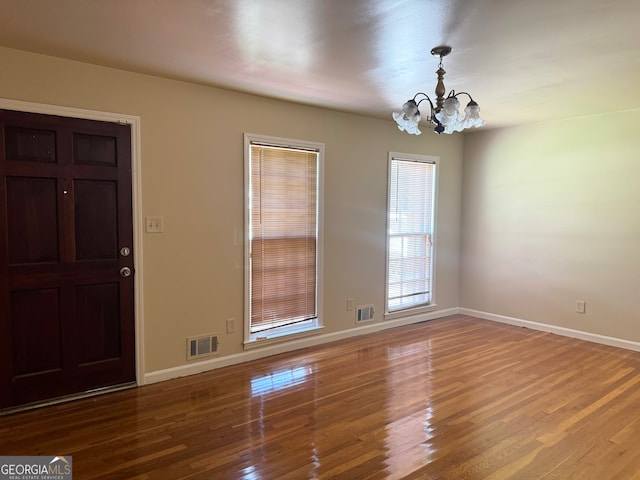 interior space featuring wood-type flooring and a notable chandelier