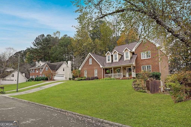 view of front of home featuring a garage, a front yard, and covered porch