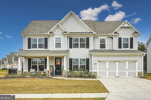 craftsman inspired home featuring a garage and a front yard