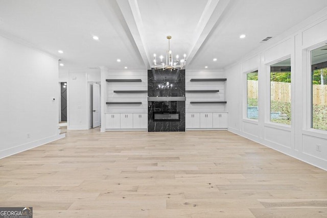 unfurnished living room with ornamental molding, light wood-type flooring, a notable chandelier, and beam ceiling