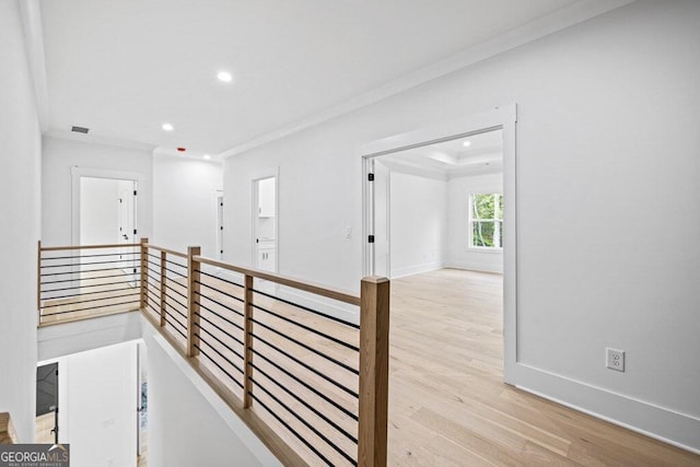 hall with light hardwood / wood-style floors and ornamental molding