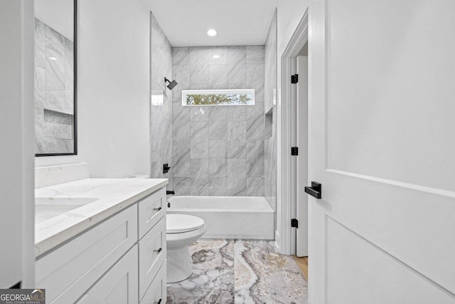 full bathroom featuring vanity, tiled shower / bath combo, and toilet