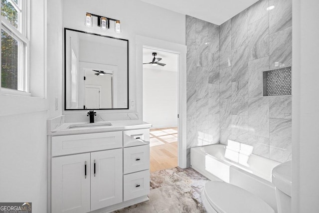 bathroom with ceiling fan, vanity, toilet, and tile walls