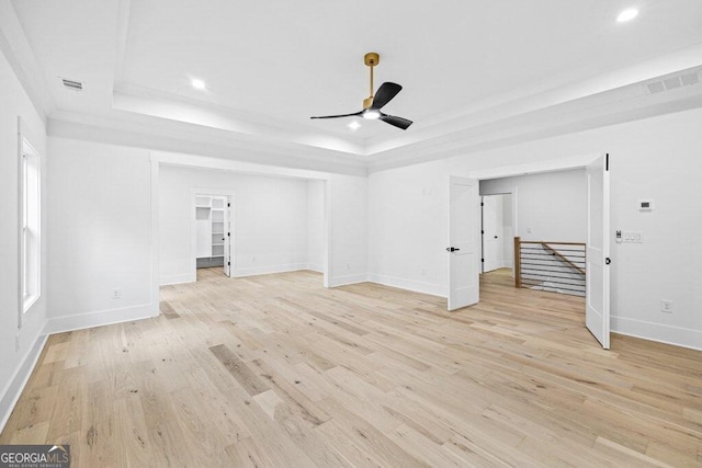 interior space featuring light hardwood / wood-style flooring, ceiling fan, and a raised ceiling