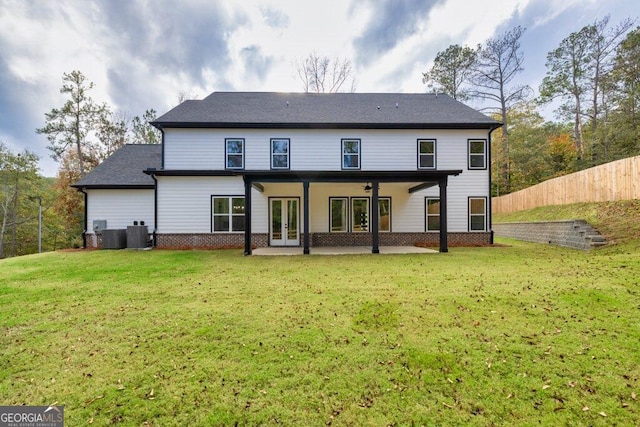 back of property featuring central AC unit, a lawn, and a patio area