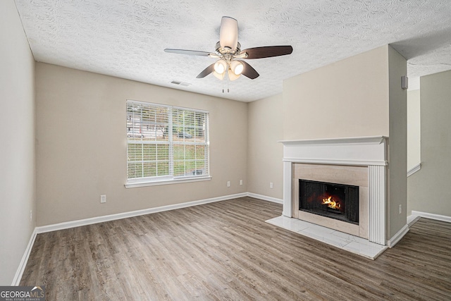 unfurnished living room featuring a textured ceiling, ceiling fan, and wood-type flooring