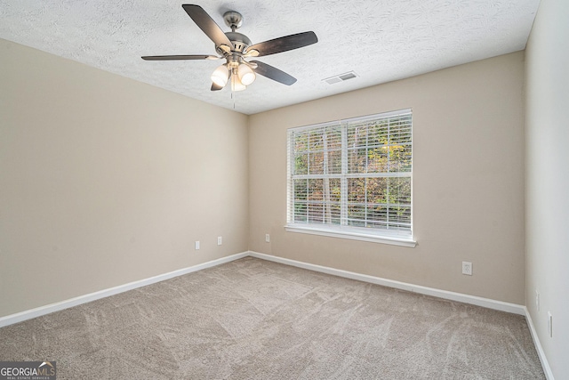 carpeted spare room with ceiling fan and a textured ceiling