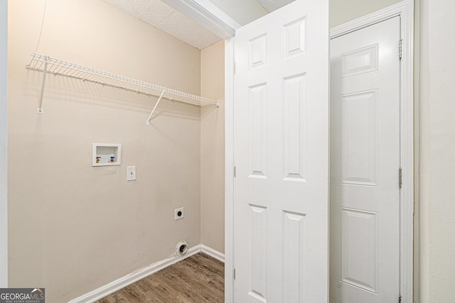 laundry area with a textured ceiling, hookup for an electric dryer, hookup for a washing machine, and hardwood / wood-style flooring