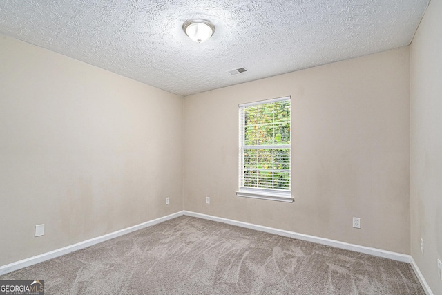 spare room featuring a textured ceiling and carpet