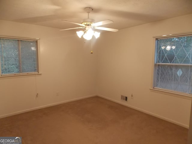 carpeted spare room with ceiling fan