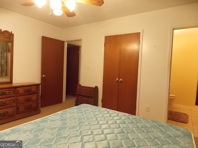 tiled bedroom with ceiling fan, connected bathroom, and a closet