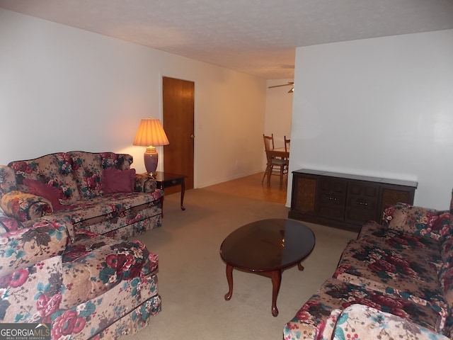 carpeted living room with ceiling fan