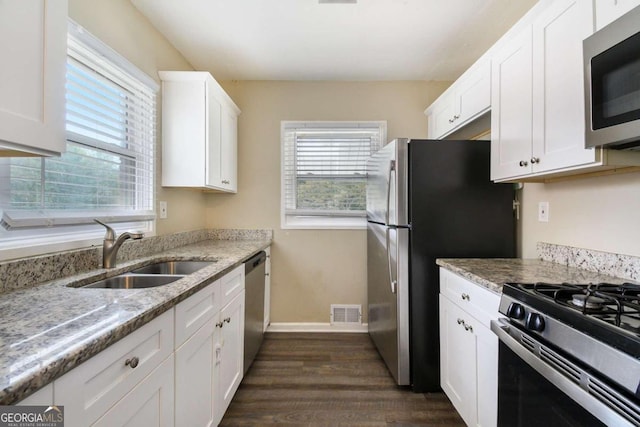 2910 Delowe Dr, Atlanta, GA 30344 - kitchen with stainless steel appliances, a sink, dark wood-style floors, white cabinetry, and baseboards