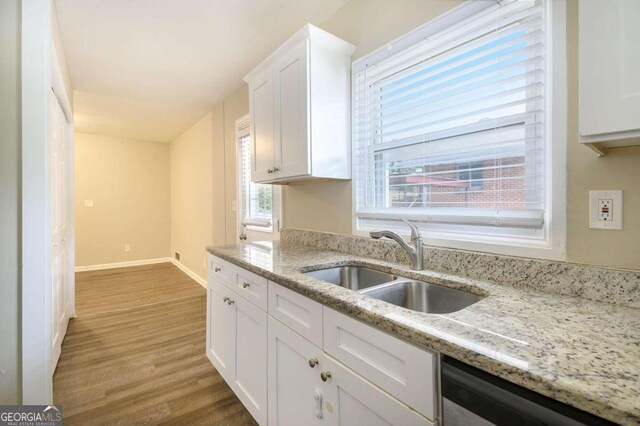 2910 Delowe Dr, Atlanta, GA 30344 - kitchen featuring a sink, dishwasher, white cabinets, wood finished floors, and baseboards