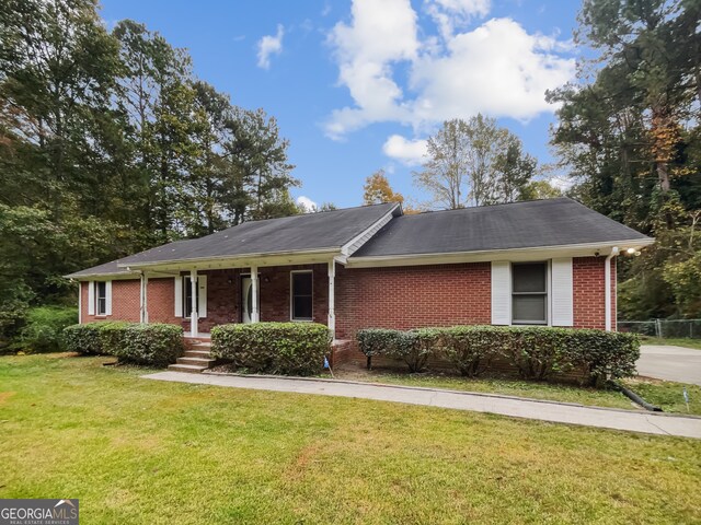 single story home with a porch and a front lawn