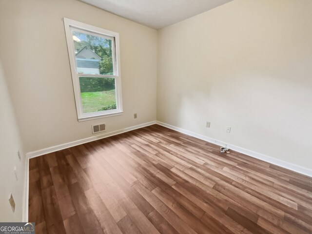 unfurnished room with wood-type flooring