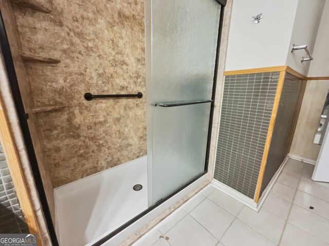 bathroom featuring a shower with shower door and tile patterned floors