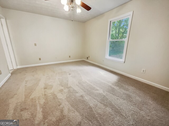 carpeted spare room featuring ceiling fan