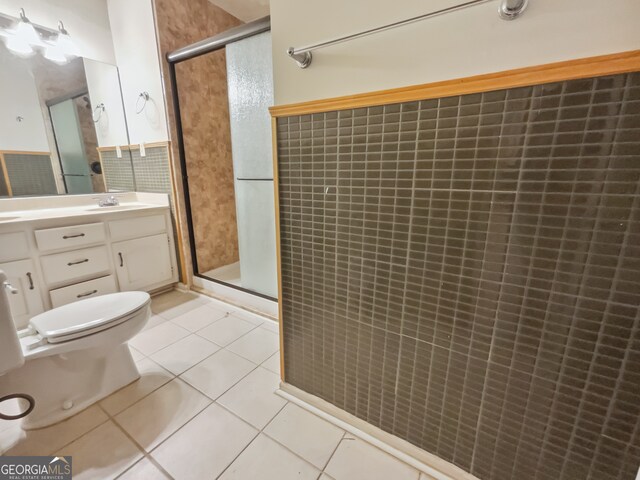 bathroom with vanity, tile patterned floors, toilet, and an enclosed shower