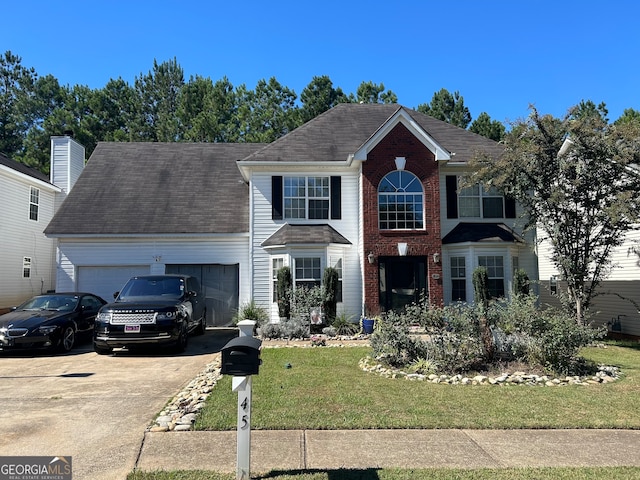 view of front of house with a garage and a front lawn