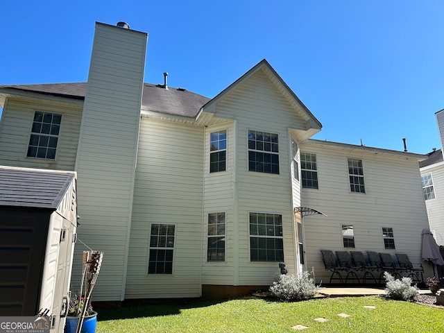 rear view of property featuring a yard and a patio area