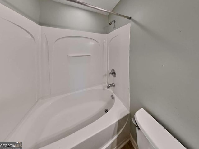 bathroom featuring washtub / shower combination and toilet