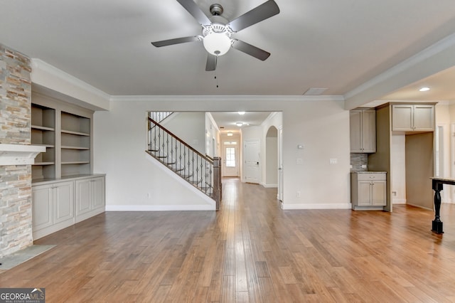 unfurnished living room featuring light wood-type flooring, ceiling fan, and ornamental molding