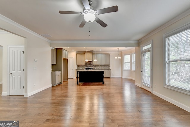 unfurnished living room with ornamental molding, wood-type flooring, and ceiling fan