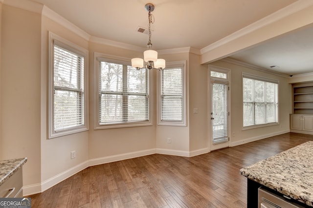 unfurnished dining area with a chandelier, wood-type flooring, and crown molding