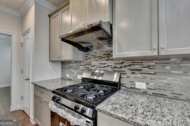 kitchen with tasteful backsplash, light stone counters, stainless steel gas stove, and crown molding