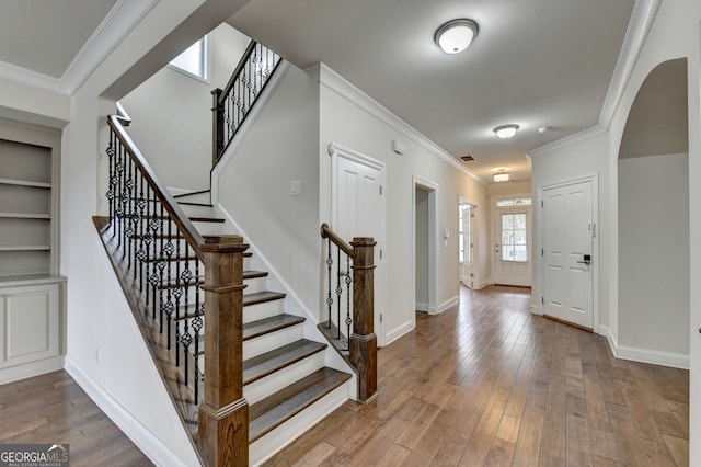 entryway featuring hardwood / wood-style floors and crown molding