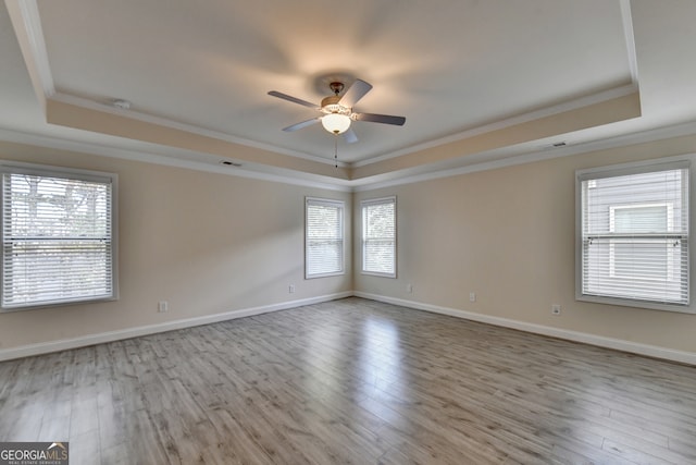 spare room with light hardwood / wood-style flooring and a tray ceiling