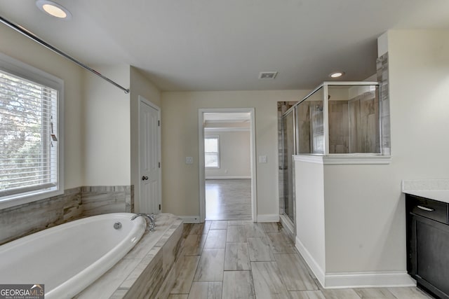 bathroom featuring separate shower and tub, vanity, and plenty of natural light