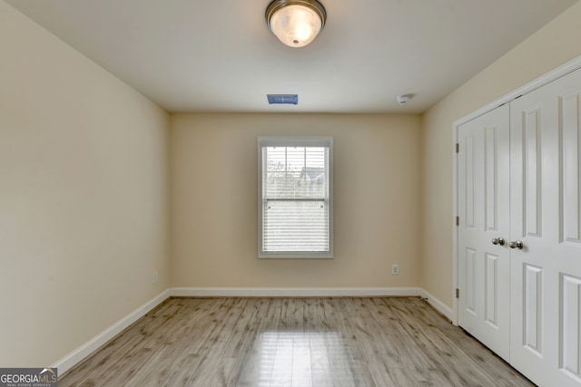 unfurnished bedroom with a closet and light hardwood / wood-style flooring