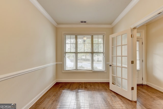 doorway to outside with wood-type flooring and ornamental molding